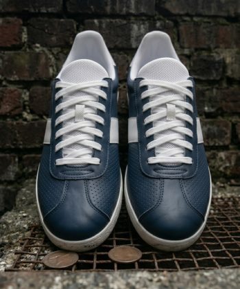 Front-facing view of Retro Glide navy leather sneakers highlighting the micro-perforated toe box and crisp white laces.
