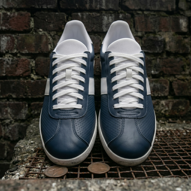 Front-facing view of Retro Glide navy leather sneakers highlighting the micro-perforated toe box and crisp white laces.