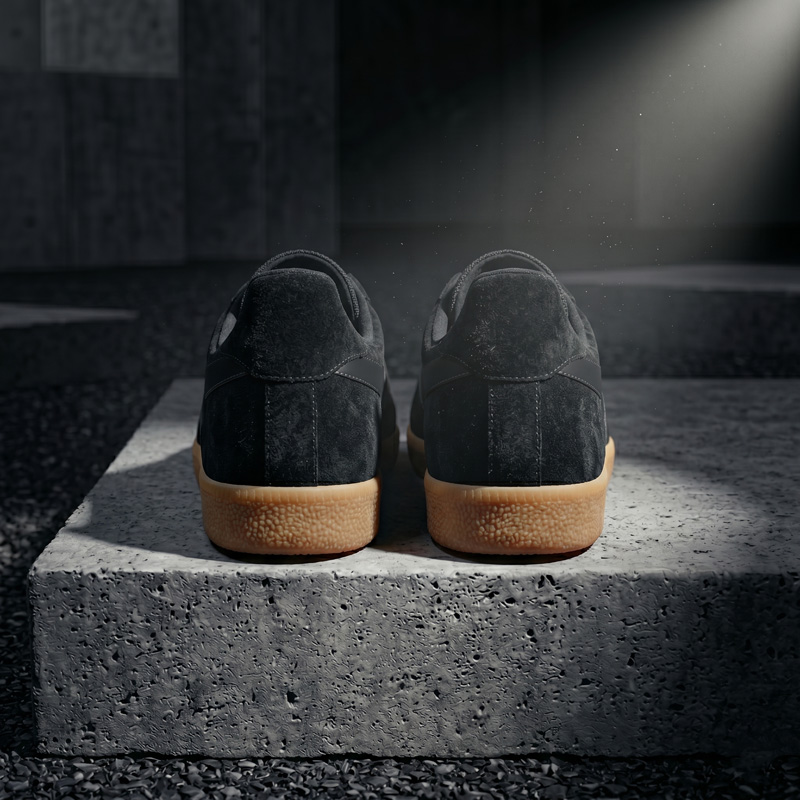 Back heel view of the Asphalt black suede sneakers displaying the suede texture and thick gum rubber sole