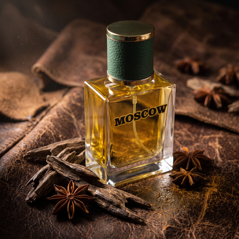 Moscow Perfume bottle resting on a rugged brown leather surface, surrounded by rich oud wood chips and star anise under moody, dramatic lighting